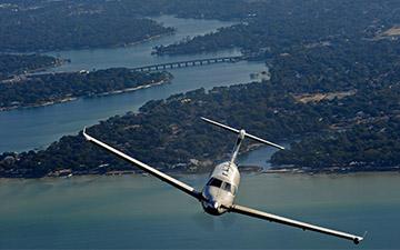 Top view of an aircraft flying over a body of water